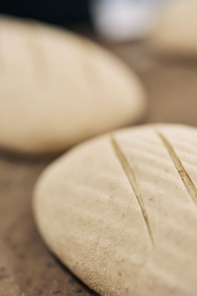 Peices of round dough on a wooden table
